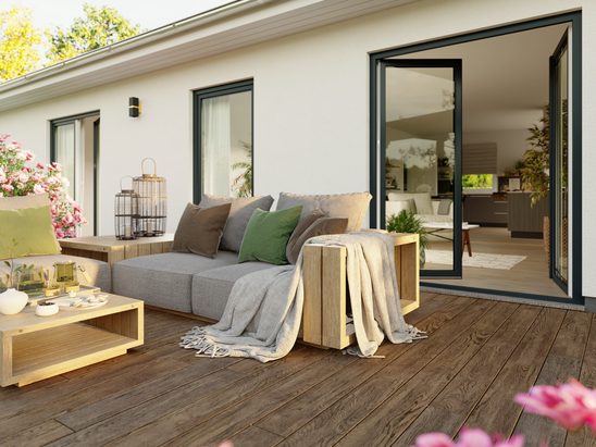 Offenes Wohnen mit Stil Terrasse des ERA 131 mit geöffneter Tür und Blick auf den hellen Wohn- und Essbereich mit Küche