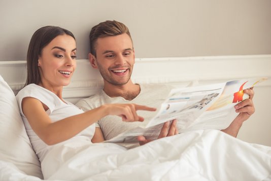 Haus-Familie-Wohnen-Serie-12-1 Glückliches Paar liest Zeitung im Bett.